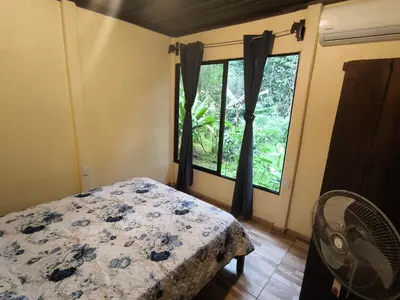 a bedroom with a bed and a large window at Cabaña escondida Venecia in Venecia