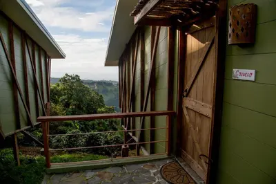 an open door to a balcony with a view at Chayote Lodge in Zarcero