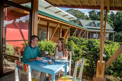 a man and woman sitting at a blue table at Chayote Lodge in Zarcero