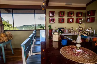 a dining room with a table and some windows at Chayote Lodge in Zarcero