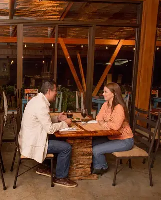 a man and a woman sitting at a table at Chayote Lodge in Zarcero