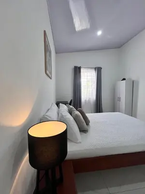 a bedroom with a bed with a table and a refrigerator at EBK Surf Apartamento 1 in Santa Cruz
