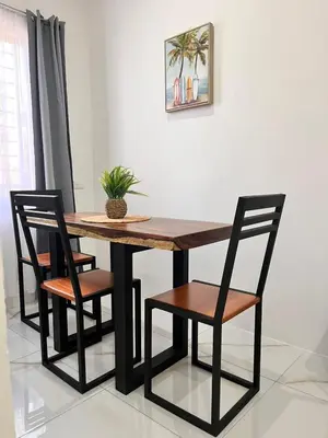 a dining room table with two chairs and a table and a plant at EBK Surf Apartamento 1 in Santa Cruz