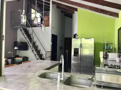 a kitchen with a sink and a stainless steel refrigerator at Luz En El Cielo Eco-B&B/Hostel in Montezuma