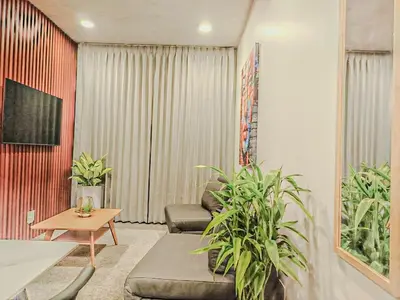 a living room with a couch and some plants at Modern Stay in Trendy Escalante 1803 in Tapantí
