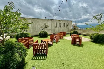 a group of chairs sitting on the grass in front of a building at Modern Stay in Trendy Escalante 1803 in Tapantí