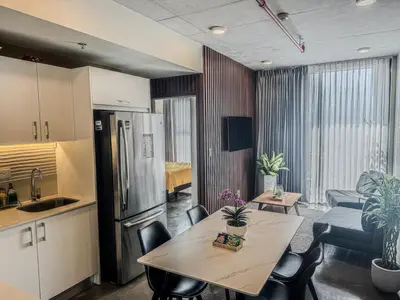 a kitchen and living room with a table and chairs at Modern Stay in Trendy Escalante 1803 in Tapantí