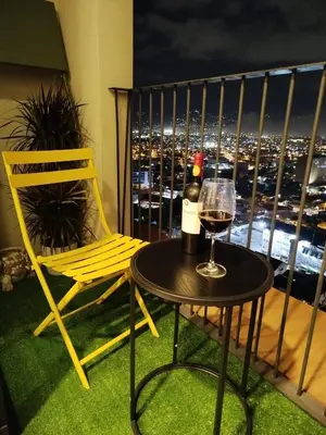 a table with a glass of wine and a chair on a balcony at Modern Stay in Trendy Escalante 1803 in Tapantí