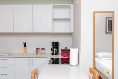 a kitchen with white cabinets and a red appliance on a counter at URBN Cozy Studio Sunset 806a in Tapantí
