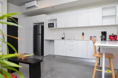 a kitchen with white cabinets and a black refrigerator at URBN Cozy Studio Sunset 806a in Tapantí