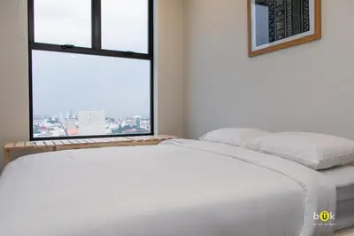 two beds in a room with two windows at URBN Cozy Studio Sunset 806a in Tapantí