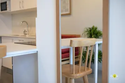 a kitchen with a counter and two wooden chairs at URBN Cozy Studio Sunset 806a in Tapantí