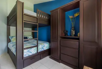 a bedroom with two bunk beds and blue walls at Coco - Laguna Azul Poolside Condo in Coco
