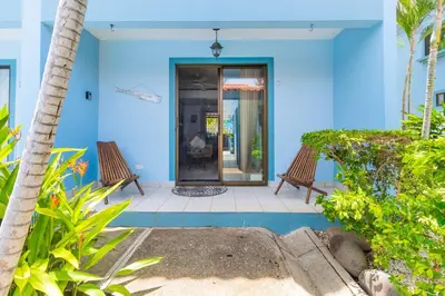 a blue house with two benches in front of it at Coco - Laguna Azul Poolside Condo in Coco