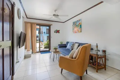 a living room with a blue couch and a table at Coco - Laguna Azul Poolside Condo in Coco