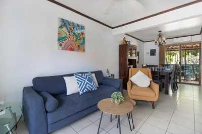 a living room with a blue couch and a table at Coco - Laguna Azul Poolside Condo in Coco