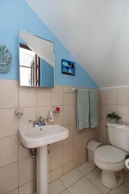 a bathroom with a sink and a toilet and a mirror at Coco - Laguna Azul Poolside Condo in Coco