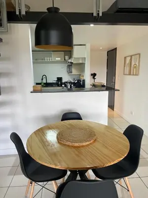 a wooden table and chairs in a kitchen at CR MARIPOSA RENTALS Brand New lake view Penthouse with office space in Santa Ana