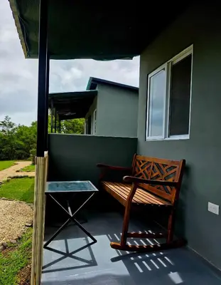 a bench sitting on the side of a house at Sea song cabin with private waterfall and river in Monteverde Costa Rica
