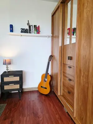a guitar is sitting in a room next to a cabinet at Sea song cabin with private waterfall and river in Monteverde Costa Rica