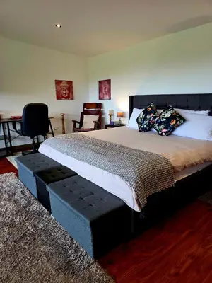 a bedroom with a large bed with pillows on it at Sea song cabin with private waterfall and river in Monteverde Costa Rica