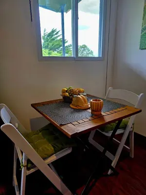 a table and chairs with a table and a window at Sea song cabin with private waterfall and river in Monteverde Costa Rica