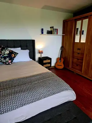 a bedroom with a bed and a guitar in it at Sea song cabin with private waterfall and river in Monteverde Costa Rica
