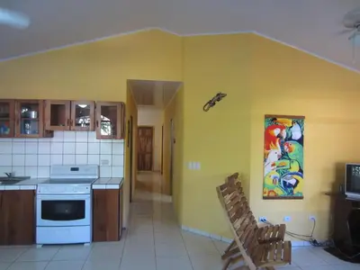 a kitchen with a yellow wall and a stove at Casa Esmeralda in Paquera