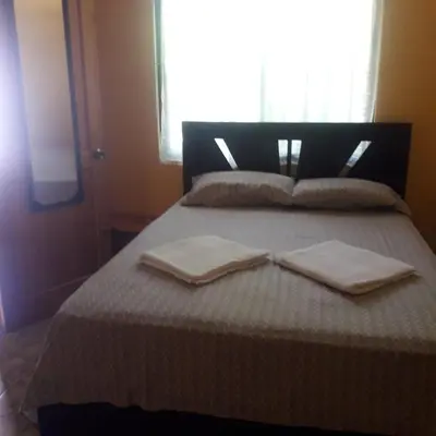 a bed with two towels on it with a window at Casa Esmeralda in Paquera