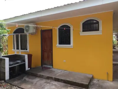 a yellow house with a door and windows at Casa Esmeralda in Paquera