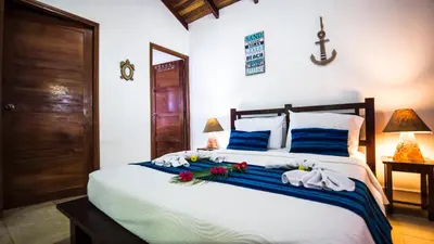 a bedroom with a bed with towels and flowers on it at Hotel El Pequeño Gecko Verde in Sámara