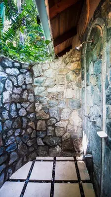 a stone wall with a shower in a room at Hotel El Pequeño Gecko Verde in Sámara