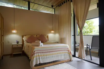 a bedroom with a bed and a large window at VED Beach Deluxe Studio 2, Steps to the Beach in Santa Teresa Beach