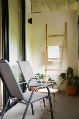 a room with two chairs and a table and a shelf at VED Beach Deluxe Studio 2, Steps to the Beach in Santa Teresa Beach