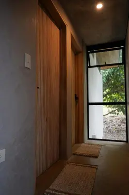 an empty hallway with a door and a window at VED Beach Deluxe Studio 2, Steps to the Beach in Santa Teresa Beach