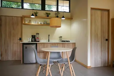 a kitchen with a table and chairs in a room at VED Beach Deluxe Studio 2, Steps to the Beach in Santa Teresa Beach
