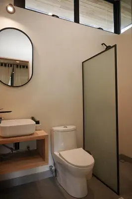 a bathroom with a toilet and a sink and a mirror at VED Beach Deluxe Studio 3, Steps to the Beach in Santa Teresa Beach
