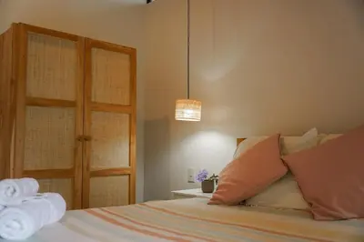 a bedroom with a bed with towels on it at VED Beach Deluxe Studio 3, Steps to the Beach in Santa Teresa Beach