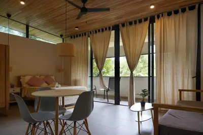 a living room with a table and chairs and a bedroom at VED Beach Deluxe Studio 3, Steps to the Beach in Santa Teresa Beach
