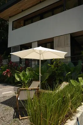 a white umbrella sitting in front of a building at VED Beach Deluxe Studio 3, Steps to the Beach in Santa Teresa Beach