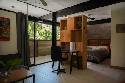 a room with a desk and a bedroom with a bed at VED Beach Apt 4 - Steps to the Beach in Santa Teresa Beach