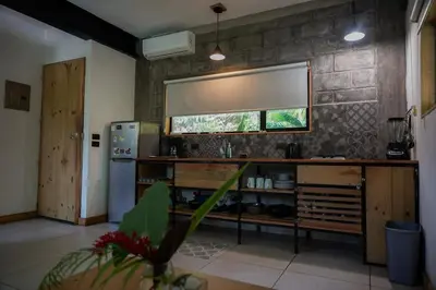 a kitchen with a counter with a refrigerator and a window at VED Beach Apt 4 - Steps to the Beach in Santa Teresa Beach