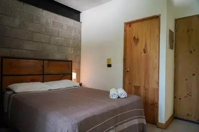 a bedroom with a bed and a wooden door at VED Beach Apt 4 - Steps to the Beach in Santa Teresa Beach