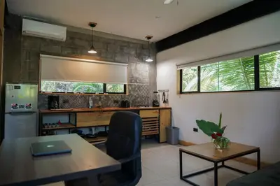 a living room with a table and a desk with a laptop at VED Beach Apt 4 - Steps to the Beach in Santa Teresa Beach