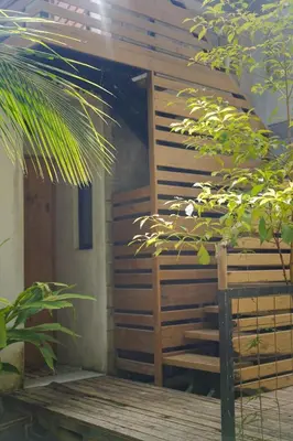 a wooden cabin with a wooden door and some plants at VED Beach Apt 4 - Steps to the Beach in Santa Teresa Beach