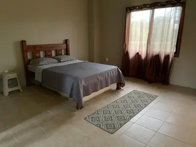 a bedroom with a bed and a window and a rug at Luciernaga in Bahia