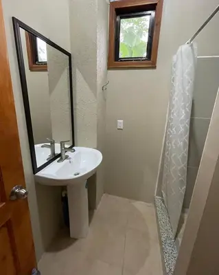 a bathroom with a sink and a shower with a mirror at Luciernaga in Bahia
