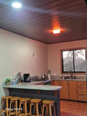 a kitchen with a counter top and some stools at Guacamaya in Bahia