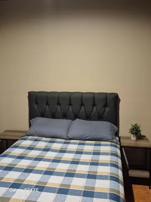 a bed with a blue and white checkered blanket at Guacamaya in Bahia