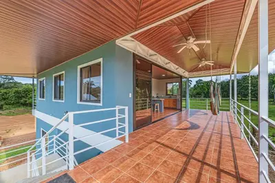 an open porch of a house with a ceiling fan at Guacamaya in Bahia